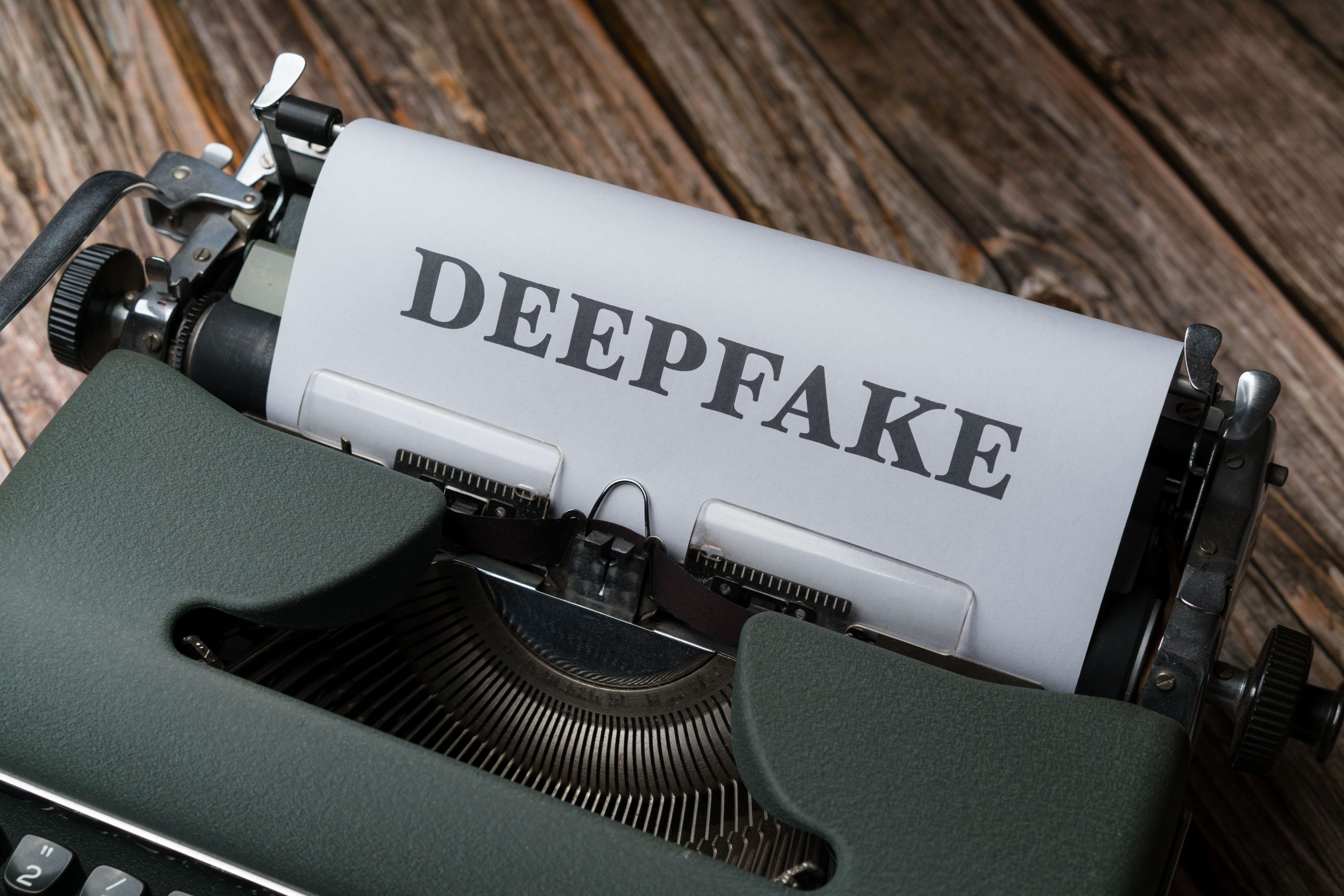 Close-up of a typewriter with the word Deepfake typed on paper, illustrating AI content detection concerns