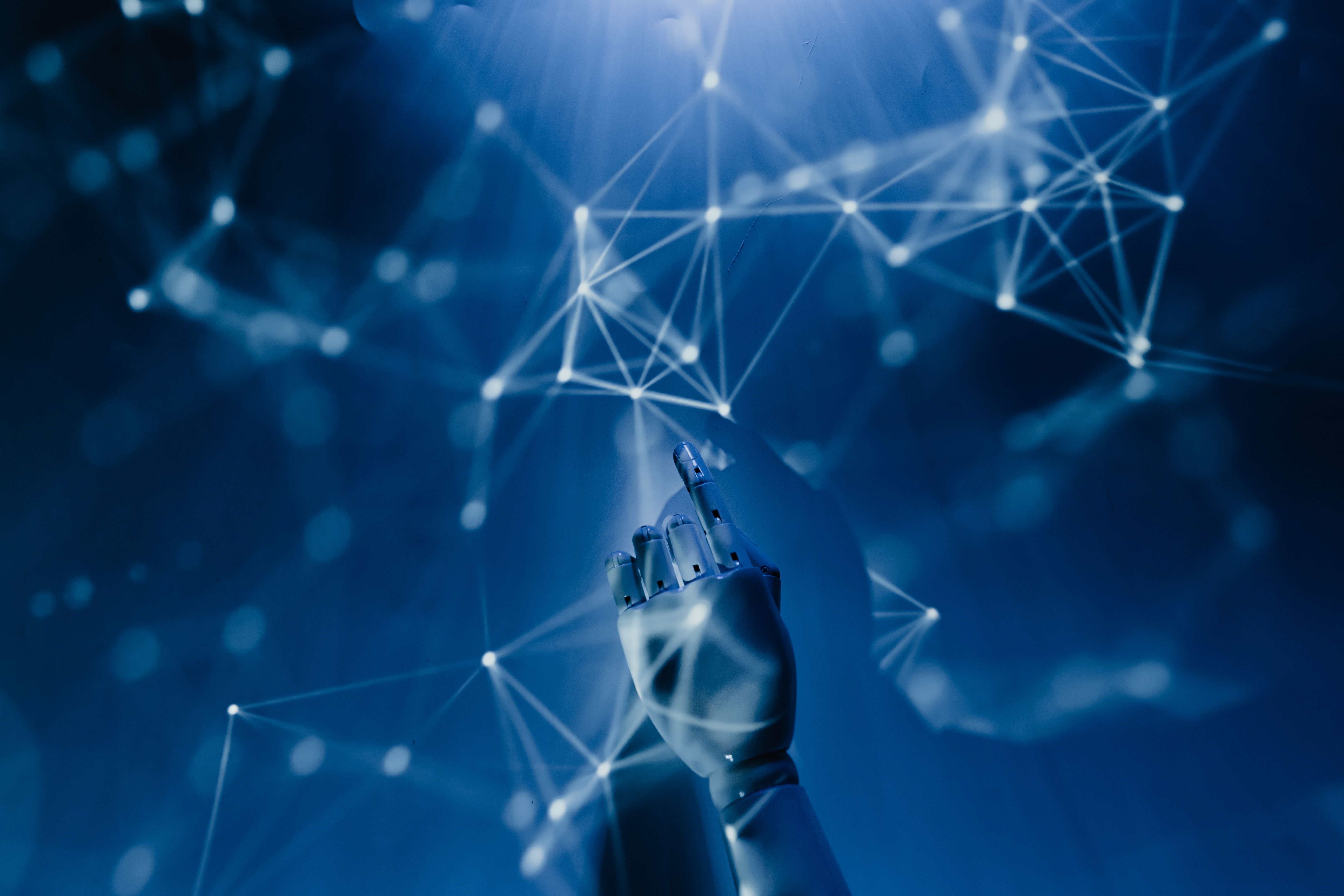 Robotic hand reaching into a digital network symbolizing artificial intelligence technology