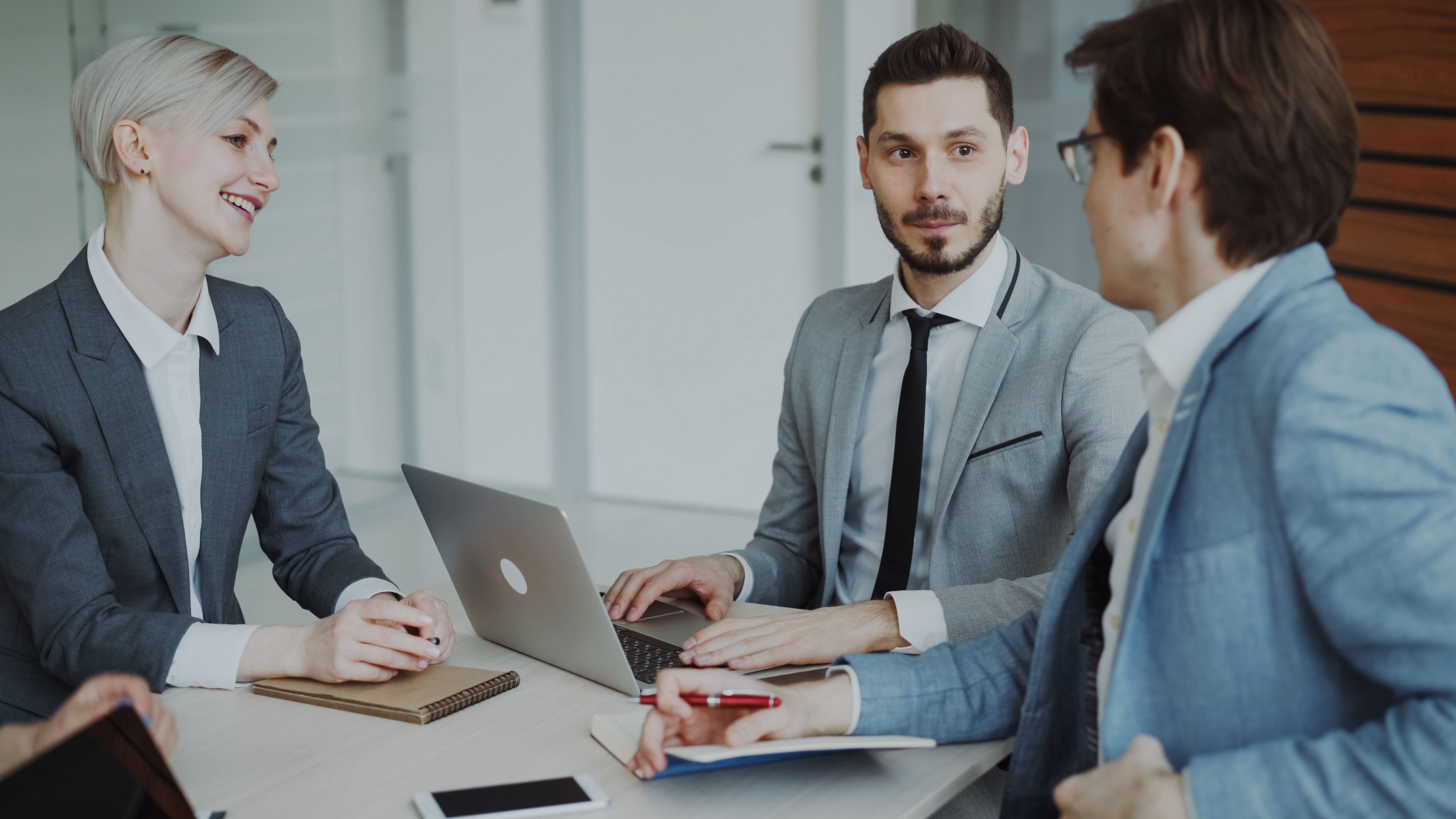 Business professionals in a meeting with laptops discussing AI content detection strategy